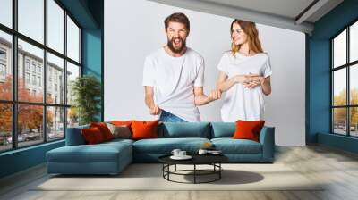 emotional man in a t-shirt and a woman in jeans on a light background fabric clothing fashion style Wall mural