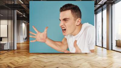 emotional man in white t-shirt anger blue background Wall mural