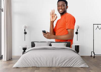 happy guy of african appearance gesturing with his hands and holding a mobile phone  Wall mural