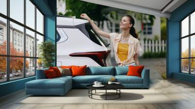 Happy woman enjoying outdoor lifestyle next to a modern white car in a sunny environment Bright colors and cheerful mood capture the joy of urban living and adventure Wall mural