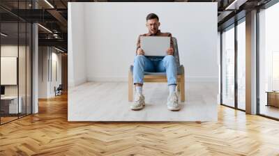 I can not believe it concept. Shocked scared young man with laptop on knees made critical mistake hates operation problems computer breakdown opening mouth. Remote Job Work from home. Front view Wall mural