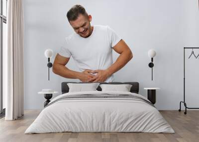 Man abdominal pain, gastritis and appendicitis inflammation, in white T-shirt on white isolated background, copy space Wall mural