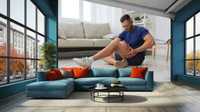 Man athlete pain and injury back arm and leg at home, sports injury bodybuilder, concept health and beauty Wall mural