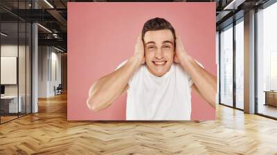 man in white t-shirt emotions gestures with hands pink background Wall mural