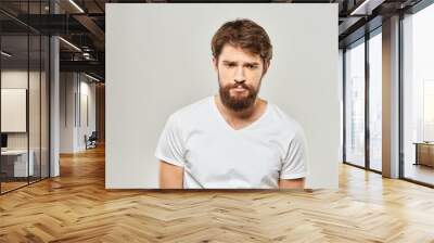 man in white t-shirt gesturing with his hands studio dissatisfaction lifestyle light background Wall mural