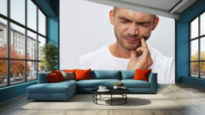 Man toothache, wisdom tooth gum inflammation, in white T-shirt on white isolated background, copy space Wall mural