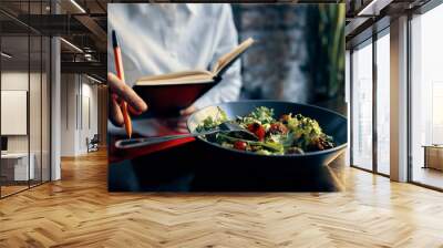 notepad with a pen in hand and salad in a plate restaurant cafe inscription Wall mural