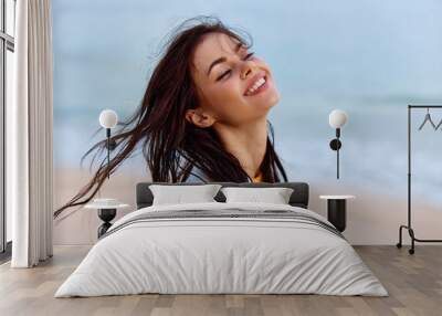 Portrait of a woman smile with teeth in a yellow tank top and white beach shirt with wet hair after swimming on the ocean beach sunset light Wall mural