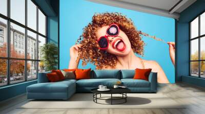 Portrait of a woman The fun curly hair tilted her head to the side red heart glasses  Wall mural