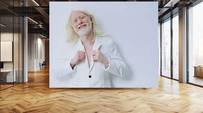 Smiling man in a white suit against a minimalistic white background, exuding confidence and positivity, showcasing a modern and vibrant style with soft lighting Wall mural