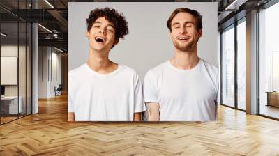 two friends in white t-shirts fun emotions isolated background Wall mural