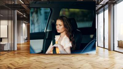 woman in car, thoughtful expression, natural light, stylish attire, urban background, casual outfit, emotional moment, contemplation, driving interior, interior design, relaxation mood, summer vibes Wall mural