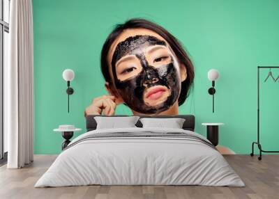 Woman in cosmetic mask, skin problem, facial treatment on green background portrait Wall mural