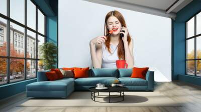 woman talking on the phone, a cup with a drink and a flower Wall mural