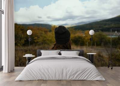 woman tourist in autumn on nature in the mountains back view Wall mural