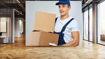 working man in uniform with boxes in his hands delivery loader lifestyle Wall mural