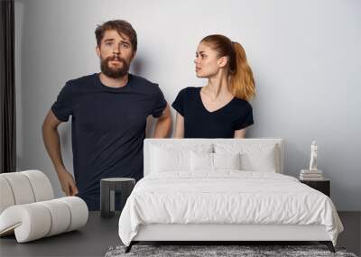 young couple in black t-shirts on a light isolated background Wall mural