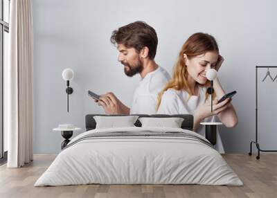 young couple with phone in hands technology communication lifestyle emotions friendship Wall mural