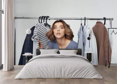 young woman chooses clothes in wardrobe Wall mural