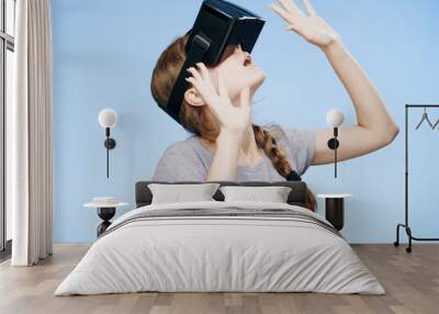 Young woman on a Blue background with virtual reality glasses Wall mural