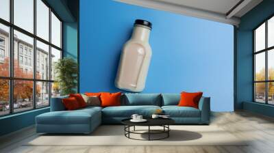 Bottle of milk on blue color background,top view Wall mural