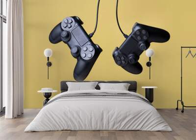 Flying air gamepads from a game console on a yellow background. The concept of games Wall mural