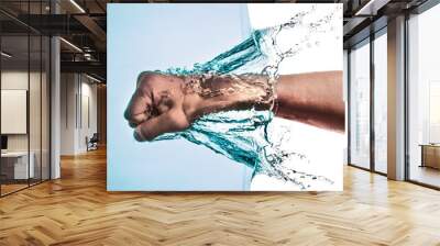 Male Fist through the Blue Water and splashing drops on a white Wall mural