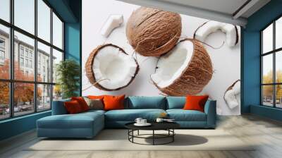 Flat lay of whole and opened coconuts lying on a white background showing the inside texture Wall mural