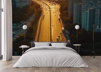 Highway traffic flowing between city buildings at sunset with long shadows Wall mural