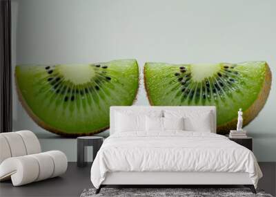 Two upright slices of kiwi fruit showcasing the vivid green hue and intricate seed patterns Wall mural