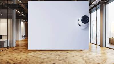 White wall has a security camera installed to provide surveillance and maintain safety Wall mural