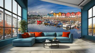 A small and cozy harbor in the town of Exmouth. There are many vessels moored here. Around the harbor are colorful beautiful houses. Devon. England Wall mural