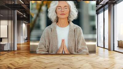 A woman is sitting on the ground and praying Wall mural