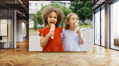 a two girl friends eats ice cream on a hot summer day. Ice cream in a waffle cone Wall mural