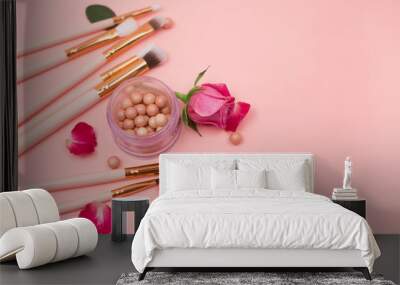  Cosmetics, makeup brushes and flowers on a pink background. Close-up. Top view. Wall mural