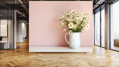 Front view of white daisy flowers in vase on table against empty pink blank wall with copy space for your advertisement, design, template or information. Interior, summer and decoration concept Wall mural