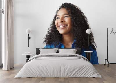 Positive human facial expressions, feeling and emotions. Picture of beautiful happy young dark skinned mixed race female with loose wavy hair looking sideways with dazzling ultra white smile Wall mural