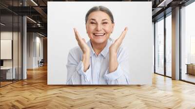 Positive vibrations and human emotions. Pleased ecstatic lucky elderly Caucasian female in blue shirt expressing excitement and joy, smiling broadly, rejoicing at success, victory or life goals Wall mural