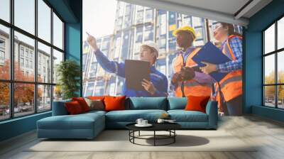 Container import export and logistic concept. Group of foreman and engineer holding tablet and wears PPE to checking inventory or job details with cargo container background. Wall mural