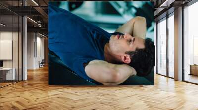 Fit caucasian handsome man sit up on machine in sportswear. Young man sit up exercise to strength their core abdominal muscles at fitness training in gym. Healthy, Sports, Lifestyle, Fitness concept Wall mural