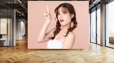 Happy cheerful young asian woman with two pigtails natural beauty makeup, Fashion model, Health wellness, Beautiful girl skin care and facial treatment. Isolated on beige pink background. Wall mural