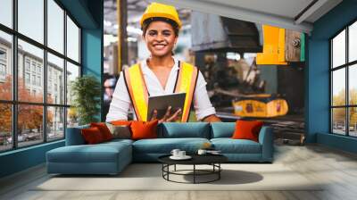 Industry maintenance engineer woman dark skin wearing uniform and safety helmet under inspection and checking production process on factory station by tablet. Industry, Engineer, construction concept. Wall mural