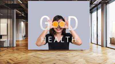 Portrait of young Asian woman holding orange slices in front of her eyes and smile over a gray background. Happy woman, Healthy eating, organic food, fruit diet, comic and people concept Wall mural