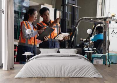 Warehouse worker and manager checks stock and inventory with digital tablet computer in the retail warehouse full of shelves with goods. Working in logistics, Distribution center. Wall mural