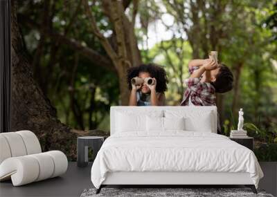 American little girl and boy explorer with his paper binoculars in the nature Wall mural