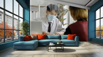 business man workers wearing face mask and clear shield having discussion through glass partition at the office Wall mural