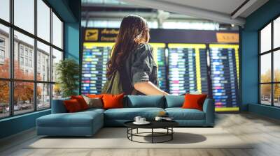 Beauty female tourist looking at flight schedules for checking take off time. People and lifestyles concept. Travel and Happy life of single woman theme. Back view portrait. Wall mural