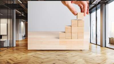 Hand arranging wood block stacking as step stair on wooden table. Business concept for growth success process. Copy space Wall mural