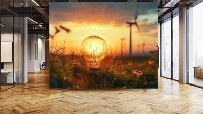 Light bulb on lush grass, wind turbines silhouette, innovation meets nature Wall mural