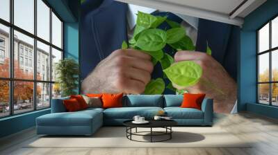 Man in suit with green leaves growing out of his tie. Green technology concept. Wall mural